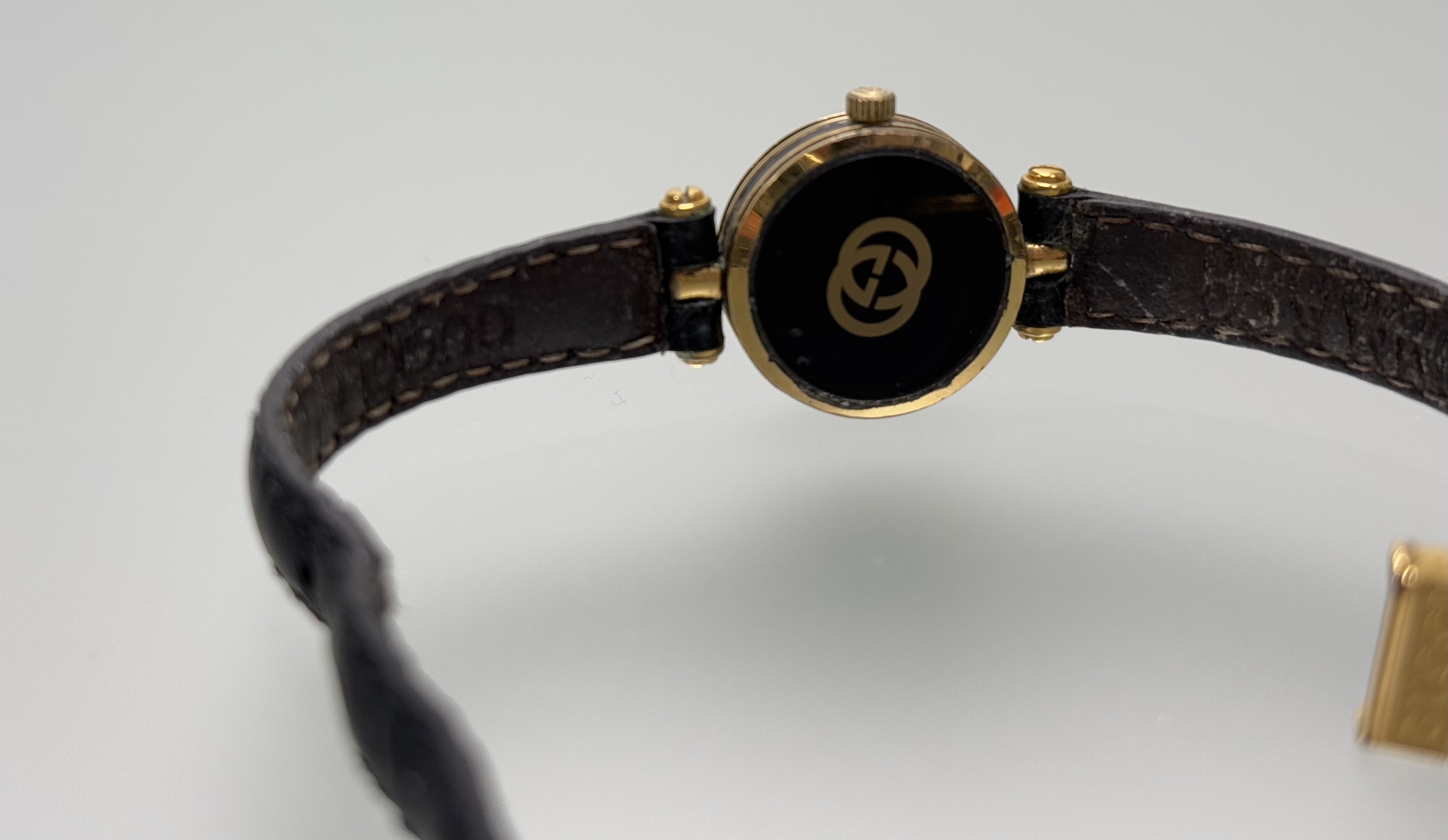A vintage Gucci wristwatch with black face and Roman numerals and enamel panel verso on original - Image 5 of 5
