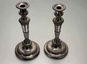 A 19thc Sheffield plated pair of weighted table candlesticks of tapered and fluted design on