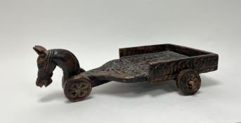 An Indian carved wooden serving tray inthe form of a horse and cart, with foliate detail to cart (l.
