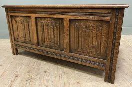 A late 19th/ early 20th century oak blanket box/ kist, moulded top over three-panel carved front,