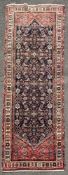 A hand-knotted Persian Hamedan runner, central panel with geometric floral pattern, enclosed
