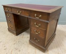 An Edwardian mahogany twin pedestal desk, with red leather skiver to top over three frieze