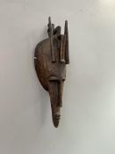 A Marka Mali tribal carved wooden mask, decorated with an elongated triangular face and slit eyes,