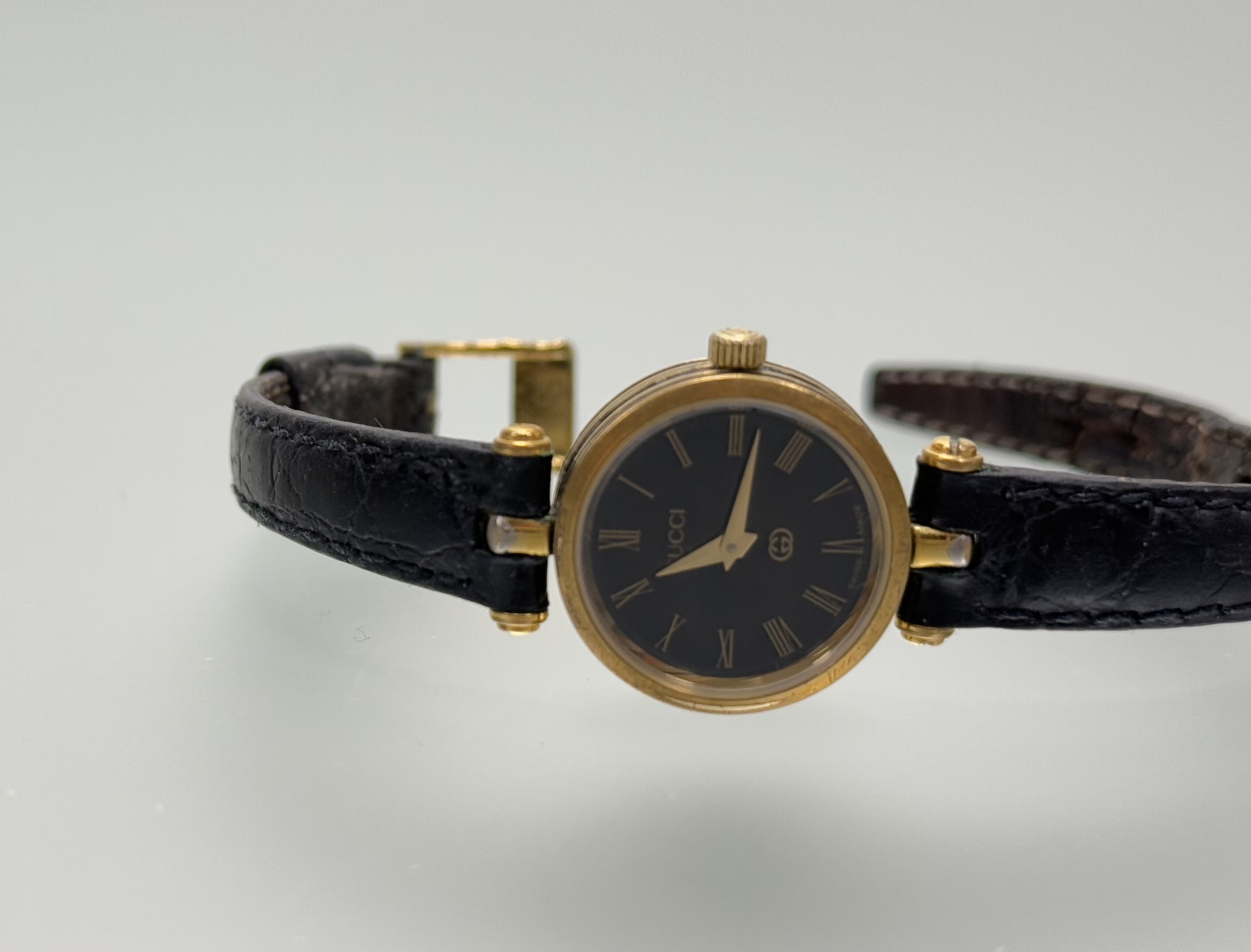 A vintage Gucci wristwatch with black face and Roman numerals and enamel panel verso on original - Image 4 of 5