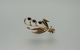 A 9ct gold spray brooch set three circular round cut faceted amethysts: l. x 4cm 4.86g