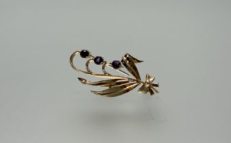 A 9ct gold spray brooch set three circular round cut faceted amethysts: l. x 4cm 4.86g