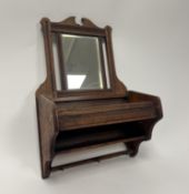 An Edwardian oak wall hanging box with bevelled mirror plate to top, and shelf and hooks to lower
