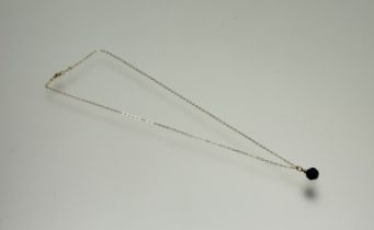 A yellow metal mounted royal blue faceted bead mounted on yellow metal trace link chain: l. x 24cm