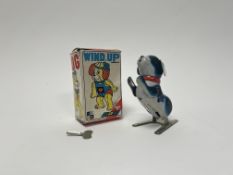 A vintage wind-up tin plate jumping dog in original box, with working key (h. 13cm)