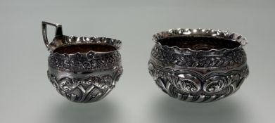 A Victorian London silver chased morning sugar bowl and milk jug: bowl h. x 5cm d. x 8cm London 1891