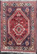 A South-west Persian Shiraz rug, central medallion with large stylized flowerhead on navy ground,