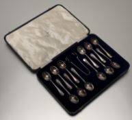A Walker & Hall Sheffield epns rat tail pattern tea spoons and tongs in original deep blue velvet-