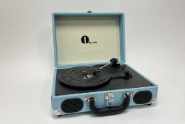 A portable 1 by One electric record player within a turquoise case with handle (l. 35cm x h.