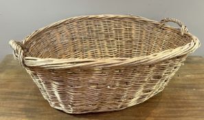 A large oval wicker log/kindling basket with twin twist handles (l. 80cm x w. 59cm x h. 28cm)