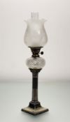 A late 19thc silver plate, pillar corthinan oil lamp with frosted etched hurricane shade, with