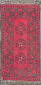 A 1920s Afghan Qarqin rug, central panel with three large guls enclosed within a geometric zig-zag