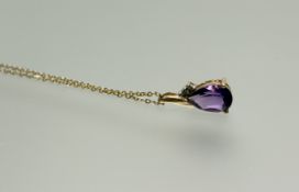 A 9ct gold mounted pear shaped faceted amethyst pendant set in scroll mount set two diuamond