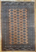 A modern hand-knotted Bokhara rug, central panel with three rows of guls and Tekke design,
