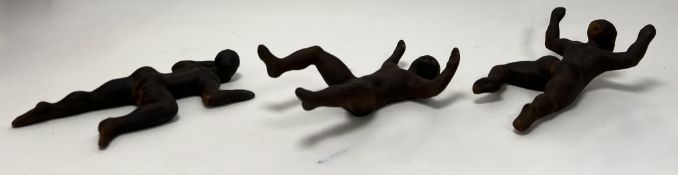 A set of three hollow ceramic male figures, bronzed textured moulded as three stages of crawling,