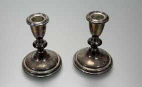 A pair of Reid and Barton sterling silver weighted short table candlesticks of baluster form on