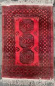 An Afghan bokhara rug, central panel with three large guls enclosed within repeating geometric