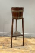 An Edwardian Arts and Crafts oak jardinaire with brass mounts (h. 91cm)