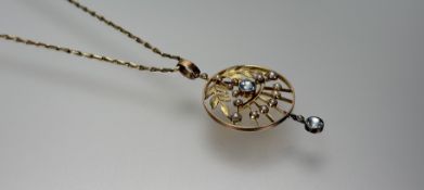 An Edwardian 15ct gold circular pendant with a central round facet cut aquamarine approximately 0.