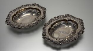 A pair of Edwardian London silver oval scalloped rococo style sweet dishes with scrolling floral