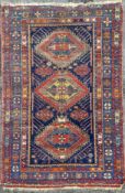 A Caucasian/ Kazak rug, central panel with three diamond medallions surrounded by geometric