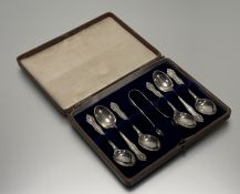 An Edwardian Sheffield silver set of six rococo-inspired tea spoons and set of tongs in original