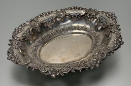 An Edwardian London silver bread basket in the Georgian taste with scaloped border and floral,