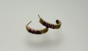 A pair of 9ct gold crescent earrings set three pink gen stones - one with cip to claw setting: l.