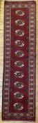 A modern hand-knotted Turkmen bokhara runner, central panel with ten gul motifs enclosed within a