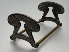 A brass expandable book rack in the Art Nouveau taste, early 20th century, the twin ends cast with