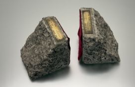 A pair of granite bookends, late 1960s, each applied with a brass plaque 