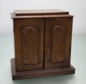 A late 19thc Walnut cased desk top cabinet, with rectangular top with moulded edge above two door