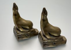 A pair of Art Deco French polished bronze bookends modelled as sea lions, each with stamped