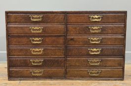 An early 20th century oak collector's chest, of twelve uniform drawers, in two banks, with brass