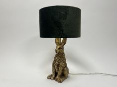A resin and gilt table lamp, the base in the form of a seated hare, with a forrest green velour drum