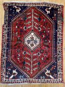An antique Persian Abadeh rug, central ivory medallion flanked by stylized flowering trees/ stems,