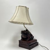 A Thomas Blakemore bronzed resin table lamp in the form of a frog and baby, raised on two books,