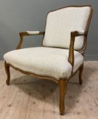 A modern French-style walnut open armchair, with shaped top and carved arms, upholstered backs and