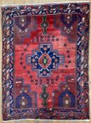 An antique Persian Afshar rug, central stepped indigo medallion flanked by floral vases and