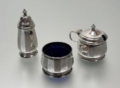 A Birmingham silver three-piece panel-sided condiment set with Bristol blue glass liners: pepperette