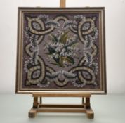 A beadwork panel of Lily of the Valley enclosed within a scolling leaf border on cross striched grey