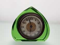 A 1930s vintage bedside table clock of facet cut green glass heart shape with silvered dial and