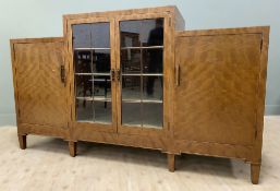 A 1930s walnut veneered sideboard, stepped top over central twin panel glazed doors, enclosing