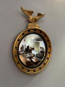 A reproduction Regency style convex giltwood mirror with carved eagle to top and ball-pattern