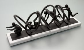 An Art Sculpture painted iron piece of a series of men tumbling through hoops, mounted on white