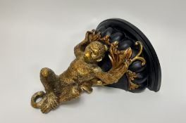 A contemporary casted resing wall self in the form of a monkey, with gilt detailing (h. 36cm) (a/f